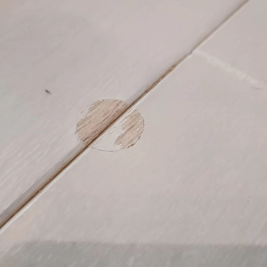 Impact mark on a varnished panel — before